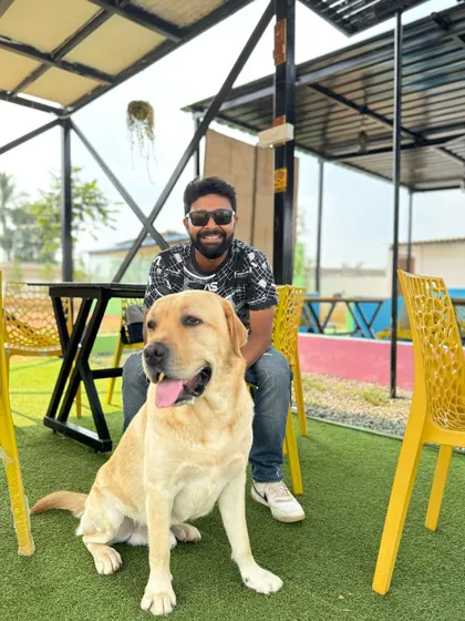 A man and his best friend, a handsome Labrador, relaxing in our cafe area. Come, bring your gang, and let loose.