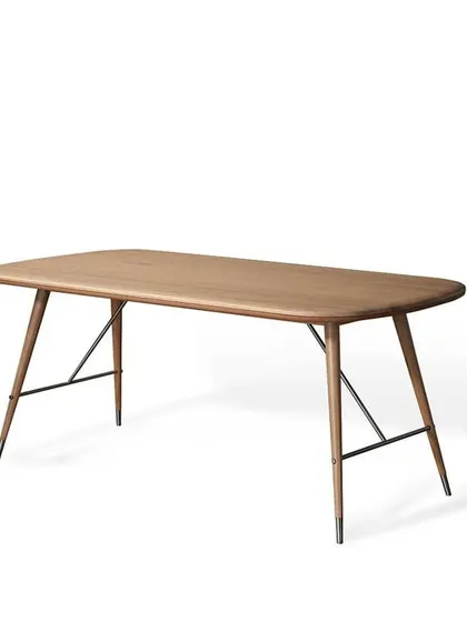 The Volta Dining Table in solid oak, with its distinctive tapered legs and matte silver steel caps. This version offers a lighter, more contemporary feel while retaining the collection's bold character.