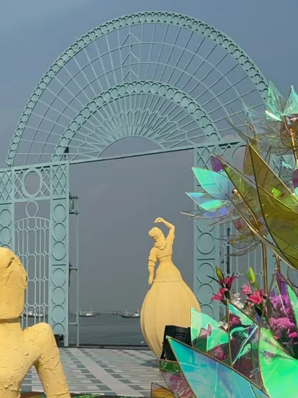 The grand archway frames the sea perfectly, while the artistic sculptures add a layer of modern elegance to the varmala stage.
