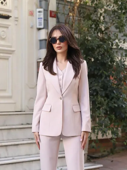 A full view of this beautiful three-piece suit in a soft, dusty pink. The set includes a single-breasted blazer, a matching waistcoat, and tailored straight-leg trousers.