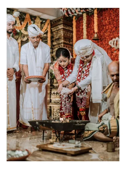 A close-up of the laja homa ritual, where the bride offers puffed rice to the sacred fire.