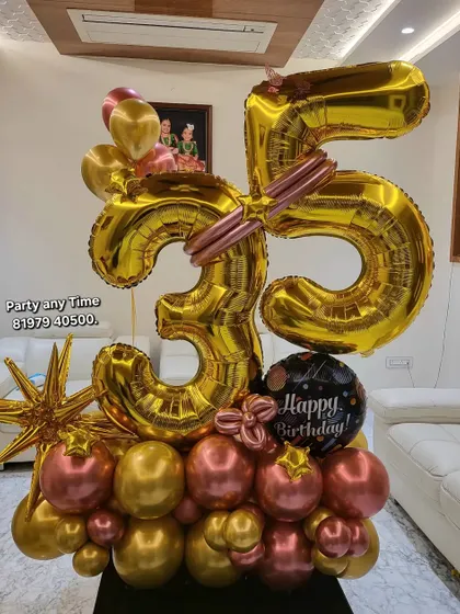 A 35th birthday balloon bouquet in gold and rose gold, featuring large foil numbers and star-shaped accents.