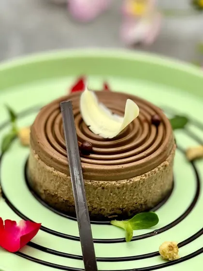 Our Hazelnut Swirl Cheesecake is a masterpiece of precision. The spiraling piped topping and clean lines showcase the technical skill and artistry of our pastry chefs.