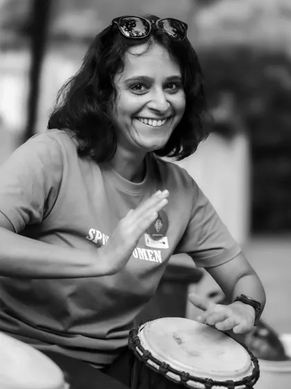 A member gets into the rhythm at the community drum circle. This black and white shot captures her focus and joy.