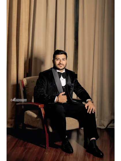 A classic seated portrait of the groom on his engagement day. The warm lighting and formal pose create a timeless and elegant image.