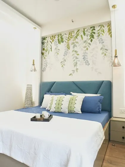 A closer look at the nature-inspired bedroom. The geometric pattern on the headboard contrasts nicely with the organic feel of the wallpaper.