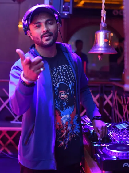 At the decks, ready to drop the next track. I bring my own style and energy, mixing everything from Bolly music to big room anthems for an unforgettable party.