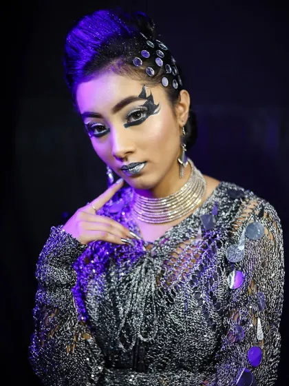 This disco-inspired look features metallic silver makeup and embellishments, showcasing a fun and creative party style.