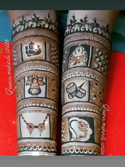 The upper arm portion of the storytelling bridal mehndi. This section includes auspicious symbols like Lord Ganesha, a kalash, dhol, and a mangalsutra, each representing a part of the wedding ceremony.