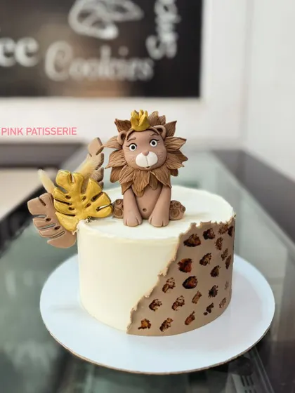 A modern and stylish lion cake. The design features a handcrafted fondant lion king and a leopard print pattern on the side for a chic jungle theme.