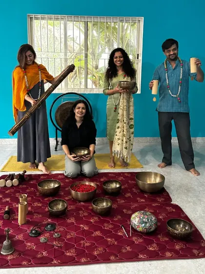 A playful group photo of our Sound Healing graduates with their instruments, including a didgeridoo and various shakers.