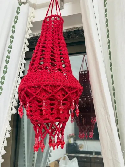Another angle of the red crochet Aakash Kandil, showing its shape and the dangling bead details.