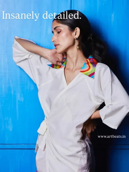 Insanely detailed. The collar on this white wrap top is a work of art in itself, with colorful, hand-embroidered patterns that make it one of a kind.