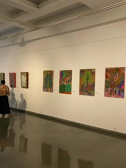 Visitors walking through the gallery space of 'ME, AMMA, WE'.