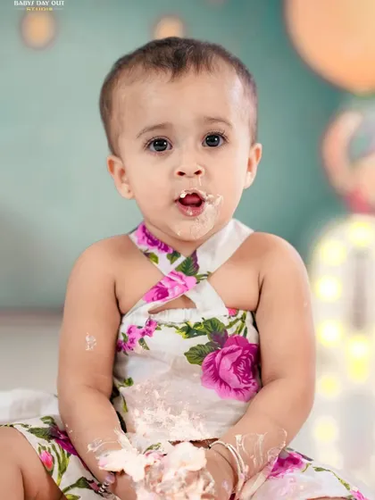 A close-up of a little girl enjoying her cake smash. The genuine expression of delight is what we love to capture.