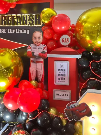 A detailed view of the personalized elements, including the child's cutout, marquee number, and a Lightning McQueen prop.