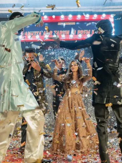 The whole group joins in for a dance, celebrating under the glittering sangeet decor.