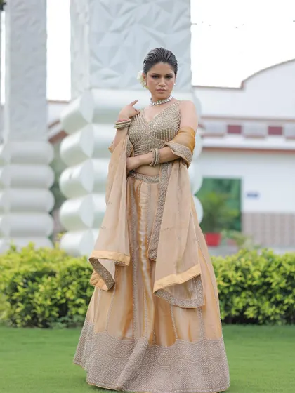 A full-length shot of the elegant gold lehenga, showcasing its shimmering fabric and minimalist design.