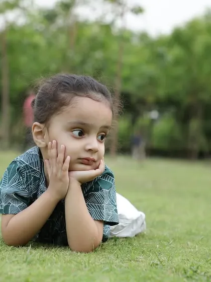 A thoughtful, candid portrait of a young child resting on the lawn. I always look for these unposed moments that reveal a child's natural personality and expressions.