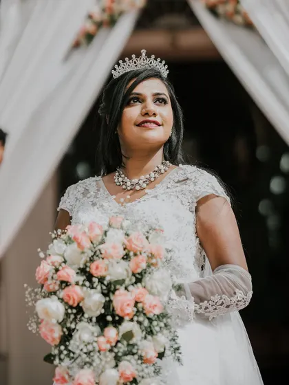 The bride holding her beautiful bouquet of pink and white roses, looking radiant as she enters the ceremony.