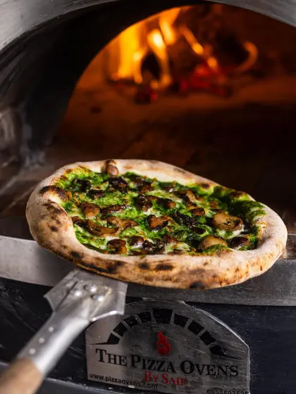 My Fungi pizza, fresh from the oven. This pie is an earthy and savory delight, featuring a spinach and mustard cream base topped with mushrooms and burrata. It's a vegetarian option that's packed with rich, complex flavors.