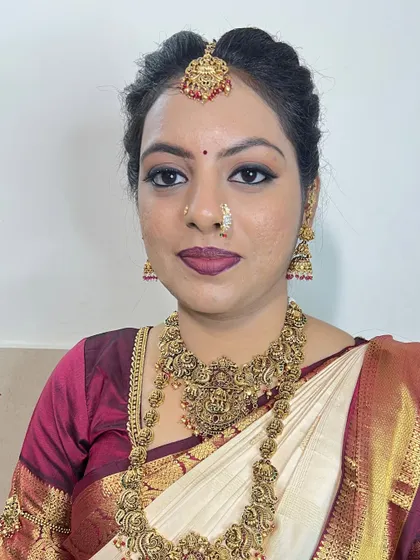 A direct portrait of the bride, showing the symmetry and precision of the makeup. The bindi and nose ring complete this classic South Indian bridal look.
