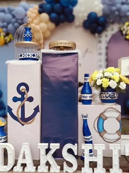 A close-up of the boat-themed cake table area, showing the detailed props and light-up name sign.