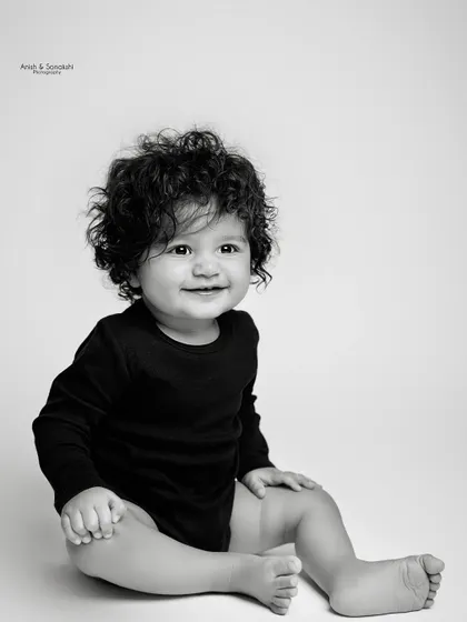 Look at those curls! Sometimes, a simple, classic black and white portrait is all you need to capture the beautiful details of your baby at this age.