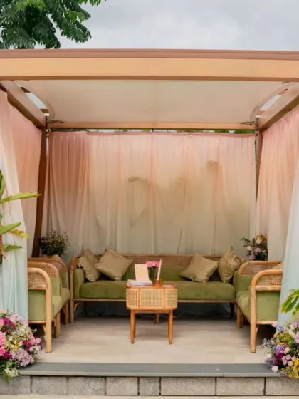 A poolside cabana draped in pastel fabrics creates a serene and sophisticated lounge space.