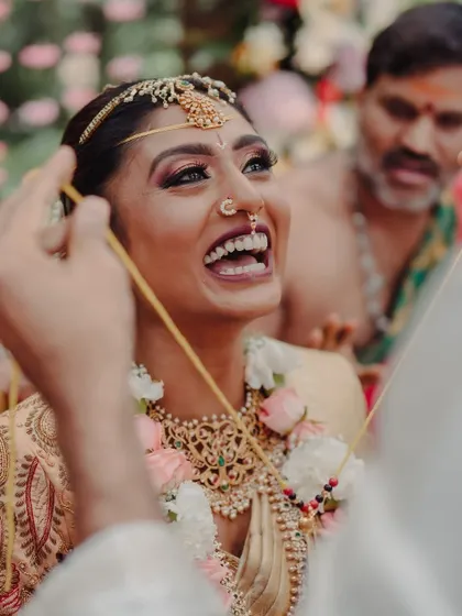 A candid shot of a South Indian bride's joyous laughter during a wedding ritual. This photo perfectly captures the genuine happiness and emotion that I strive to create the perfect setting for.