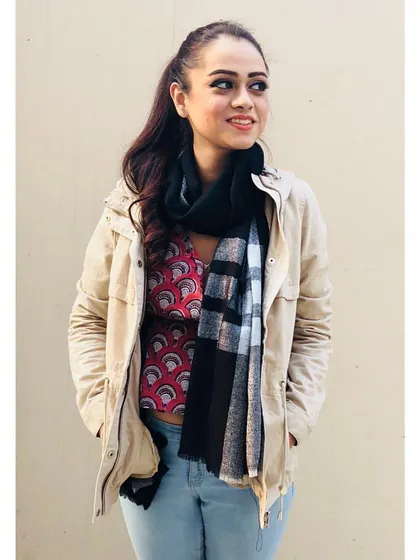 Layering is key for transitional weather. Here, I've added a light jacket and a scarf over a printed top and jeans. This not only adds warmth but also texture and dimension to the outfit.
