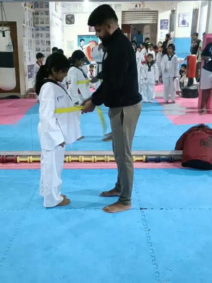 Tying a new yellow belt for a young student.