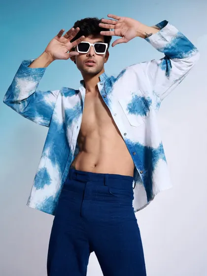 An expressive shot from the same indigo collection, with the model's open shirt revealing a confident pose. This style of photography helps sell a lifestyle, not just a piece of clothing.