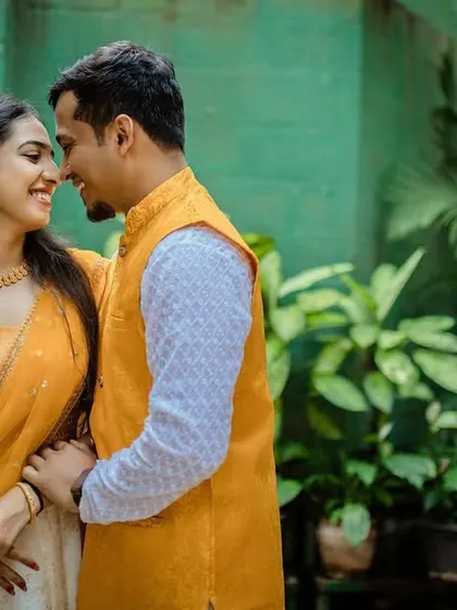 A lovely portrait of a couple during their Haldi event. Their coordinated yellow outfits look beautiful against the natural green backdrop.