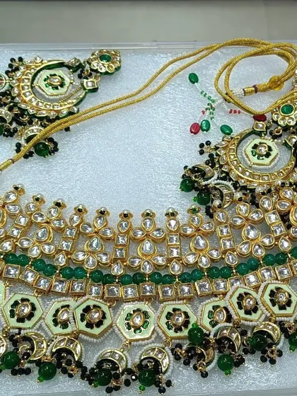 This bridal choker set features intricate meenakari work in green and black, which makes the kundan stones stand out beautifully. It is a heavy, statement piece for a bride who wants a traditional look.