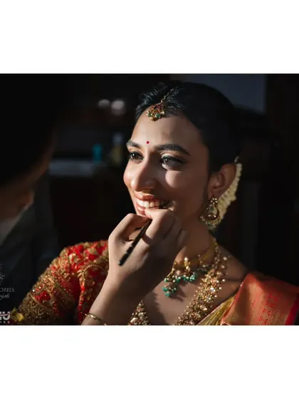 A behind the scenes moment with my bride Ritika. I am applying her lipstick, creating a natural and fresh look. We customized her makeup without false lashes due to her allergy to lash glue.