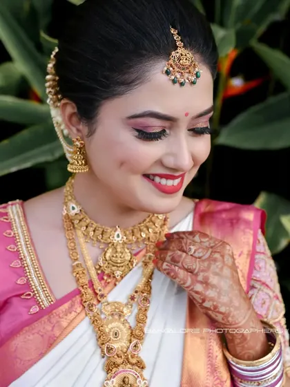 A close-up of the bride's joyful face, showcasing her beautiful smile and traditional gold jewelry. This portrait is all about capturing pure, radiant happiness.