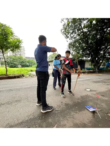 Hands-on coaching is key for beginners. I'm observing and correcting a young student's form as he practices with a traditional bow, ensuring he develops good habits right from the start.