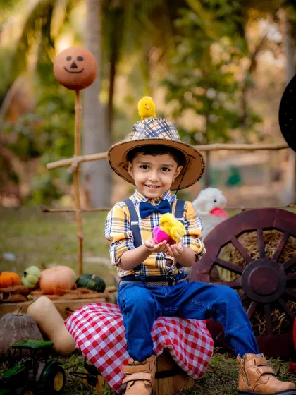 This little farmer is having a great time with his chick friends. We love incorporating playful elements to bring out the most natural and joyful expressions.