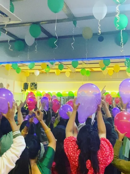 The room was filled with balloons and smiling faces during our celebration. This photo shows members participating in a fun group activity.