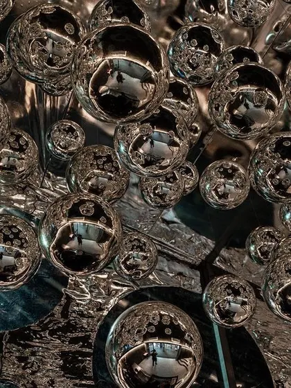 A close-up of the ceiling of the 'Silver Escapade' installation, where a constellation of mirrored spheres reflects the space below. This feature creates a dream-like dimension and highlights the transitional character of the story.
