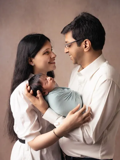New parents sharing a look of love and happiness as they cradle their newborn. This image perfectly captures the joy of starting a family.