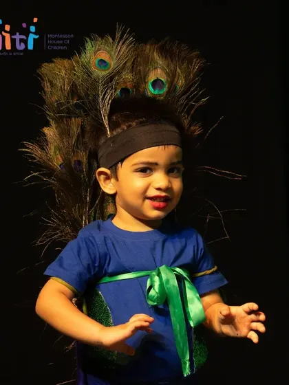 A close-up of a young boy in an adorable peacock costume, ready for his performance.
