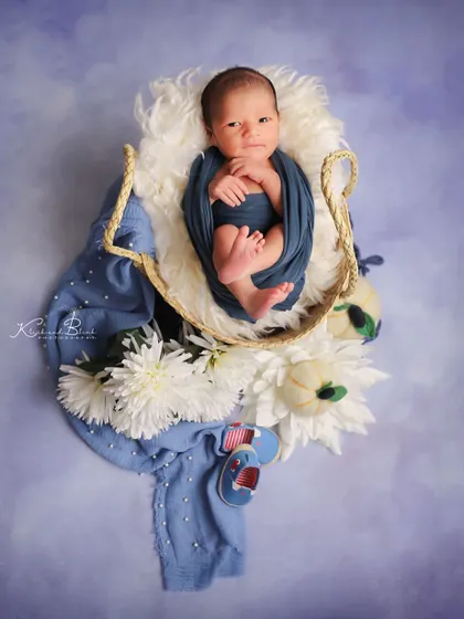 This little one was wide awake and happy. Posed in a basket with blue and white florals against a lavender sky backdrop, his curious expression is just priceless.