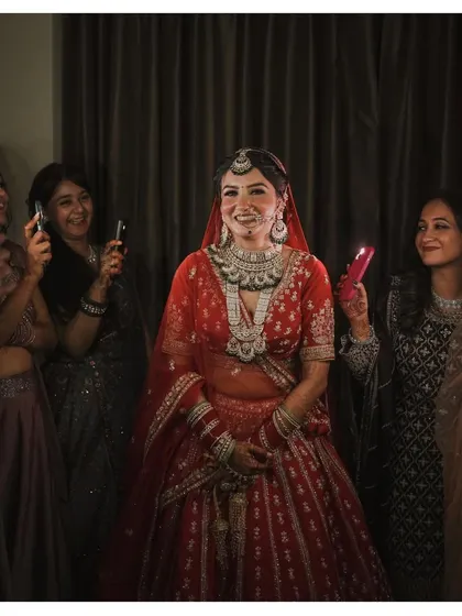 A candid moment during the getting-ready process, where the bride is surrounded by her bridesmaids who are all capturing her on their phones. A modern take on a classic scene.