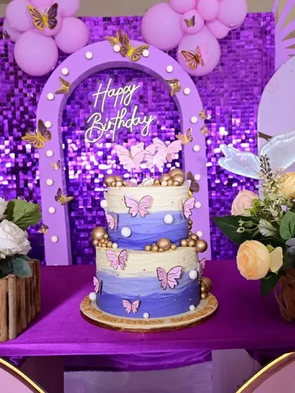 A close-up of the two-tier birthday cake, perfectly matching the purple butterfly theme.