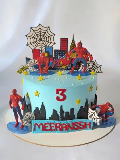 A friendly neighborhood Spider-Man cake for a 3rd birthday. This cake is decorated with multiple Spider-Man figures, a city skyline, and spider webs.