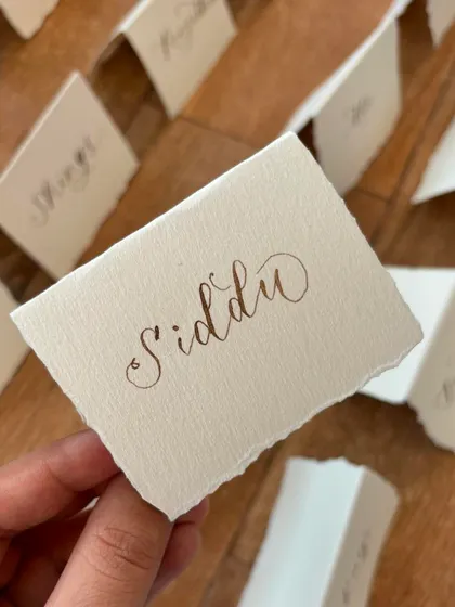 Freehand modern calligraphy on deckled edge place cards is the perfect accompaniment to a sit-down dinner. The torn edges of the handmade paper add a rustic and organic feel.