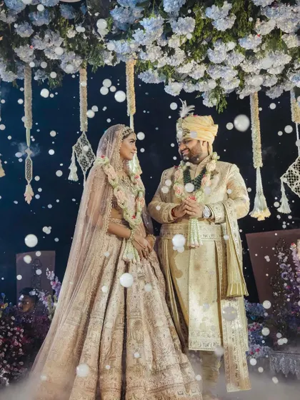 A magical moment for Manisha and Vansh under a sky of falling petals. Manisha's Tarun Tahiliani lehenga, with its intricate embroidery, looks absolutely ethereal.