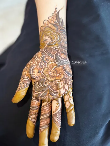 This design features a beautiful cuff at the wrist, transitioning into a detailed pattern on the hand. The finger designs are intricate and unique.
